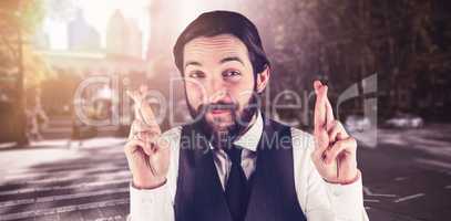 Composite image of portrait of smiling businessman with fingers crossed