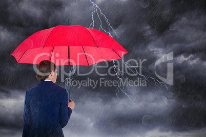 Composite image of rear view of businesswoman carrying red umbrella
