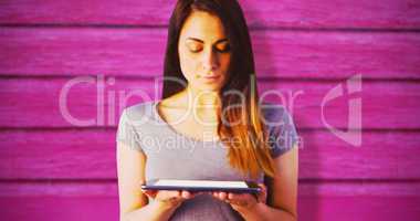 Composite image of young brunette holding digital tablet