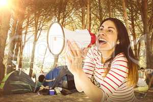 Composite image of young woman shouting with megaphone