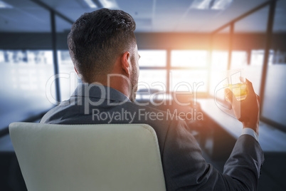 Composite image of rear view of businessman holding whisky glass