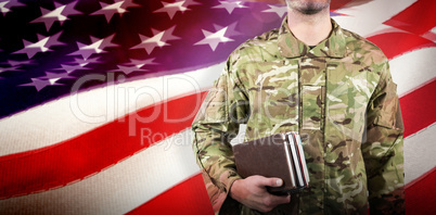 Composite image of mid section of soldier holding books