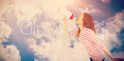 Composite image of carefree young woman making announcement with megaphone