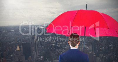 Composite image of full length rear view of businesswoman carrying red umbrella and briefcase