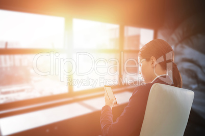 Composite image of full length of businesswoman using mobile while sitting on chair