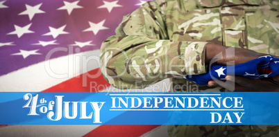 Composite image of mid section of soldier holding american flag