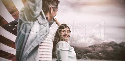Happy couple holding American flag on shore