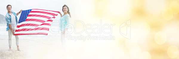 Portrait of couple holding american flag on beach