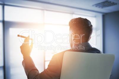 Composite image of rear view of businessman holding cigar