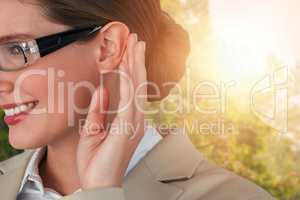Composite image of close up of smiling businesswoman trying to listen
