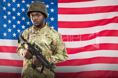 Composite image of portrait of confident soldier holding rifle