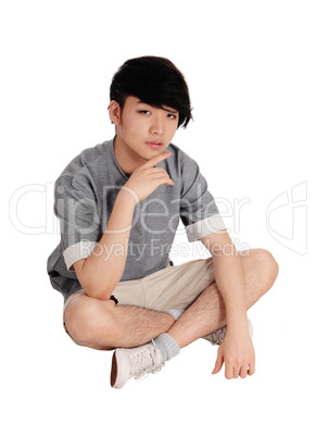 Young Asian man sitting on floor.