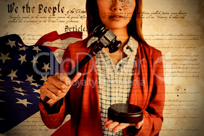 Composite image of businesswoman banging a law hammer on the gavel