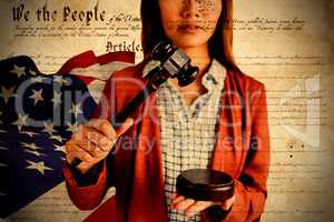 Composite image of businesswoman banging a law hammer on the gavel