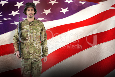 Composite image of full length portrait of soldier with rifle
