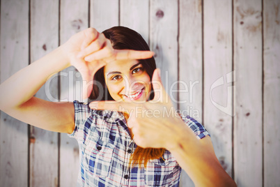 Composite image of portrait of woman looking through hands