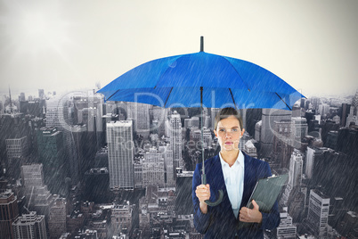 Composite image of portrait of businesswoman holding blue umbrella and clipboard