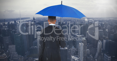 Composite image of rear view of businessman carrying blue umbrella and briefcase