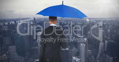 Composite image of rear view of businessman carrying blue umbrella and briefcase