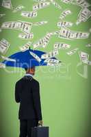 Composite image of rear view of businessman holding blue umbrella and briefcase