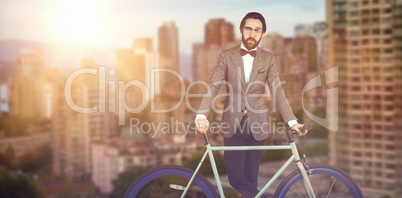 Composite image of portrait of businessman with bicycle
