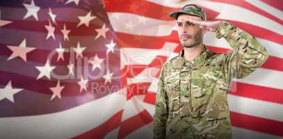 Composite image of confident soldier saluting