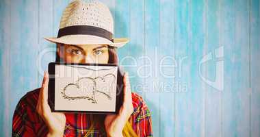 Composite image of portrait of woman hiding face with digital tablet