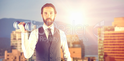 Composite image of portrait of businessman holding dumbbell