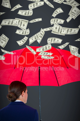 Composite image of rear view of businesswoman carrying red umbrella