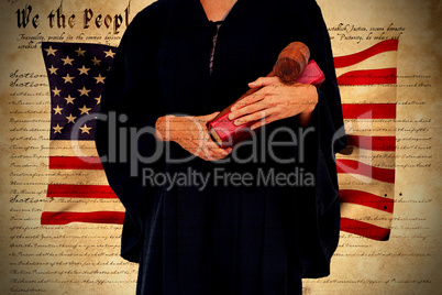 Composite image of midsection of female lawyer holding gavel and book