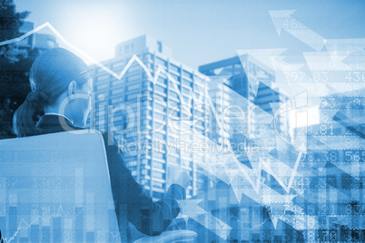 Composite image of rear view of businesswoman holding water glass while sitting on chair