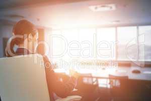 Composite image of rear view of businesswoman holding water glass while sitting on chair