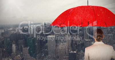 Composite image of rear view of businesswoman carrying red umbrella