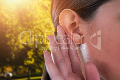 Composite image of close up of businesswoman trying to listen
