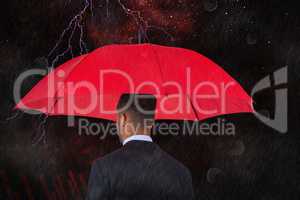 Composite image of rear view of businessman carrying red umbrella