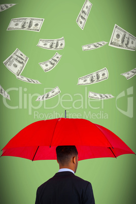 Composite image of rear view of businessman carrying red umbrella