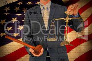 Composite image of male lawyer holding scale and gavel against white background