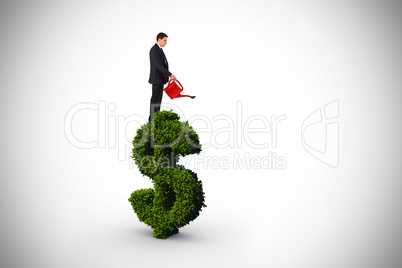 Composite image of businessman holding red watering can