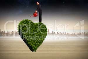 Composite image of businesswoman using red watering can