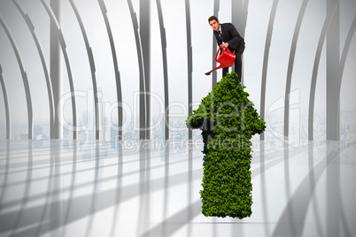 Composite image of businessman watering with red can