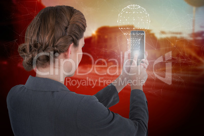 Composite image of businesswoman using mobile phone