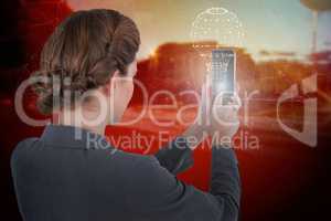 Composite image of businesswoman using mobile phone