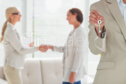 Composite image of mid section of female executive showing new house key