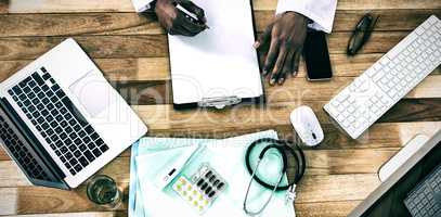 Doctor writing on clipboard at desk