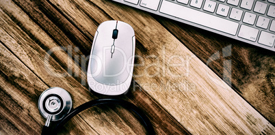 Overhead view of wireless computer mouse and keyboard with stethoscope