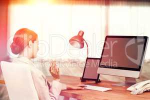 Composite image of young businesswoman using computer