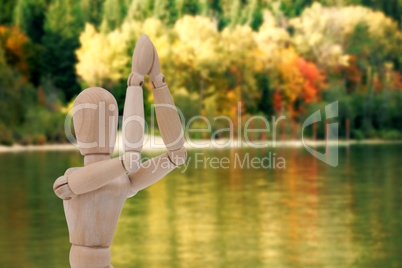 Composite image of wooden figurine standing with both the hands joined