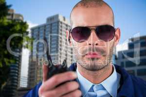 Composite image of portrait of security officer talking on walkie talkie