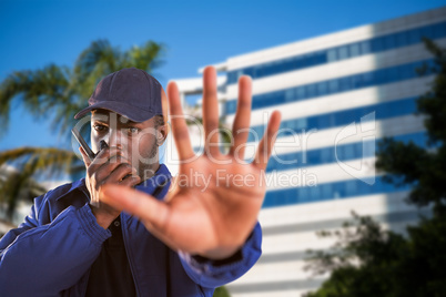 Composite image of portrait of confident security talking on walkie talkie and making stop gesture