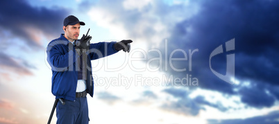 Composite image of security officer pointing away while talking on walkie talkie Composite image of security officer pointing away while talking on walkie talkie
